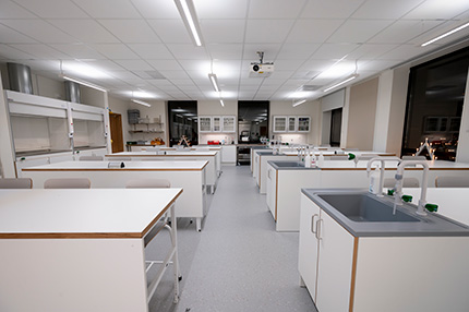 Labbsal i naturvetarhuset med vita bänkar med diskho i.
