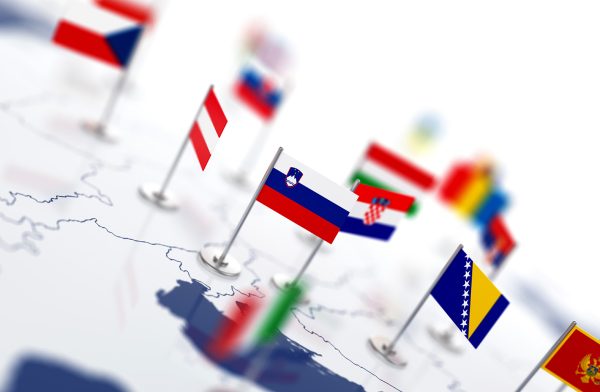 Sloveniens flagga i fokus på europakarta med flera länders flaggor.